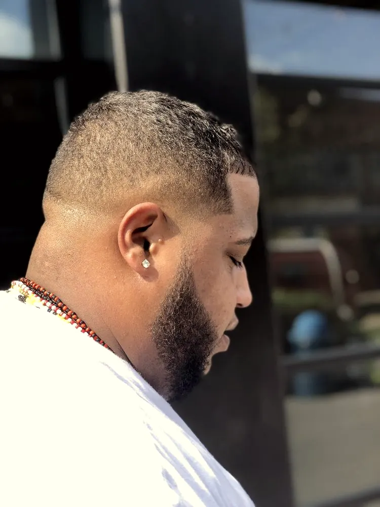 Bald fade blended into a lined-up beard