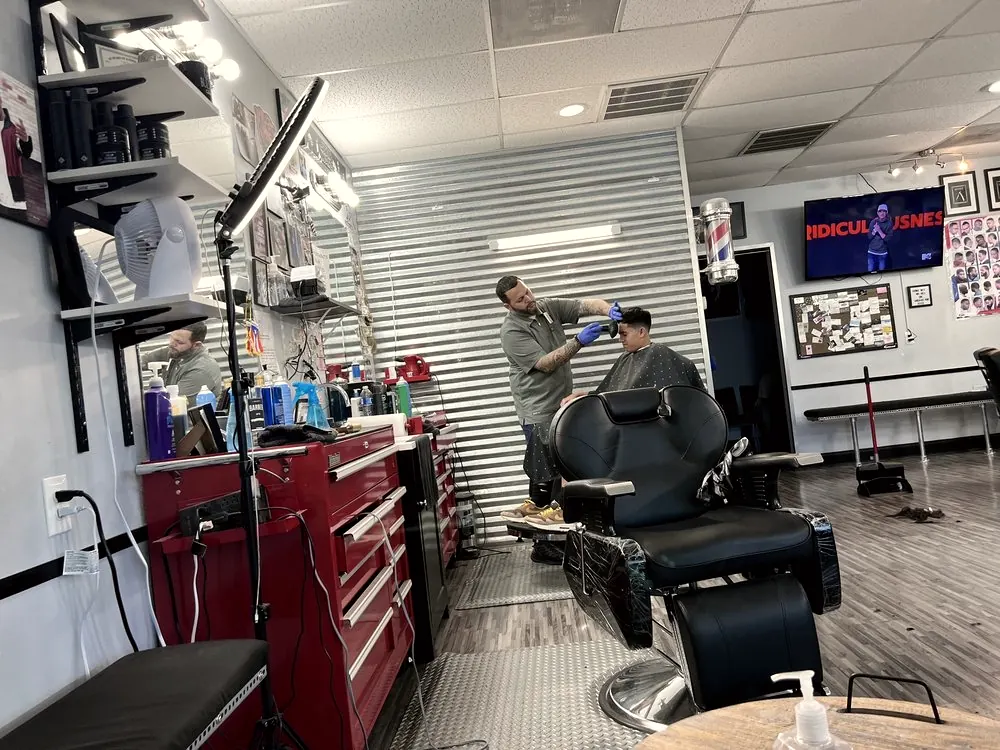 A barber at work beside a red station